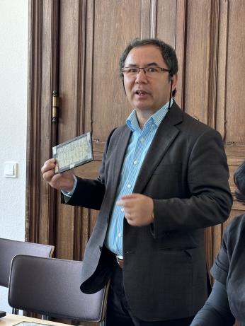 man wearing glasses holding manuscript while presenting