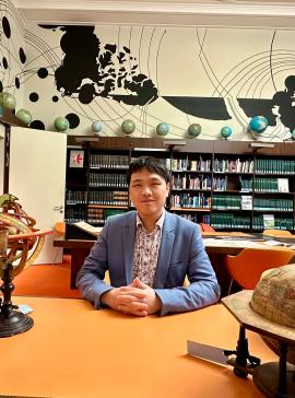 Alvin Yang sitting in a library, smiling