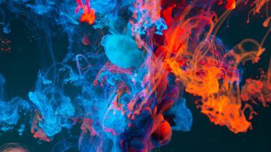 photograph of blue and orange smoke merging with each other on a black background