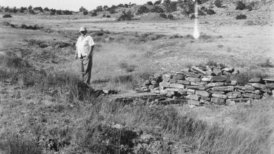 A man stands beside a checkdam